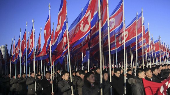 North Koreans parade with the North Korean flag in Kim Il-sung Square in Pyongyang, North Korea.