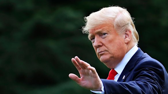 President Donald Trump waves as he walks on the South Lawn of the White House in Washington.