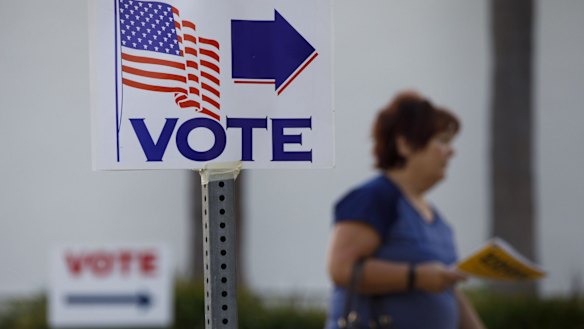 A "Vote" sign is displayed as a resident enters a polling place on Lido Isle in Newport Beach.