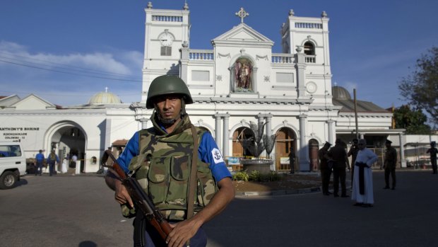 Sri Lankan air force officers and clergy stand outside St Anthony's Shrine a day after the blast in Colombo.