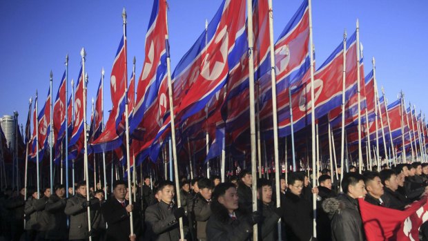 North Koreans parade with the North Korean flag in Kim Il-sung Square in Pyongyang, North Korea.