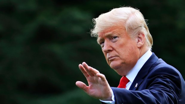 President Donald Trump waves as he walks on the South Lawn of the White House in Washington.