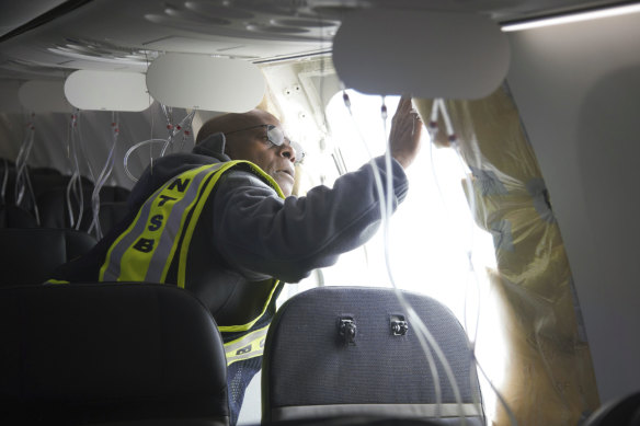 A National Transportation Safety Board investigator examining the fuselage plug area of Alaska Airlines Flight 1282.