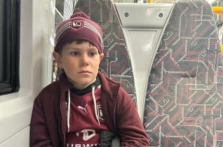 A devastated 11-year-old Carter McPherson on the train home from Suncorp Stadium.