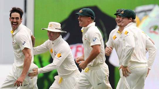 Australia's Mitchell Johnson, left, Michael Clarke, second from left, and David Warner, third from left, celebrate the wicket of England's Stuart Broad, on the fourth day of the series-opening Ashes cricket test between England and Australia at the Gabba in Brisbane, Australia, Sunday, Nov. 24, 2013. (AP Photo/Tertius Pickard)