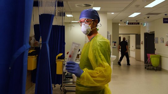 Registered nurse Damien Davis Frank holding a testing swab for the COVID-19 rapid test at St Vincent's Hospital in Darlinghurst, Sydney.