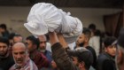  Palestinians carry the body of someone killed during Israeli airstrikes at the Al-Ahli hospital in Gaza City, Gaza.