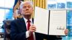 US President Donald Trump displays a signed automotive tariff executive order in the Oval Office.