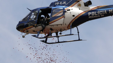 A helicopter releases flower petals on top of an iron ore mining complex to pay homage to the 110 victims killed and 238 who are still missing after a mining dam collapsed in Brumadinho, Brazil.