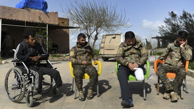 These wounded Kurdish soldiers are helping each other recuperate, but need medical attention.