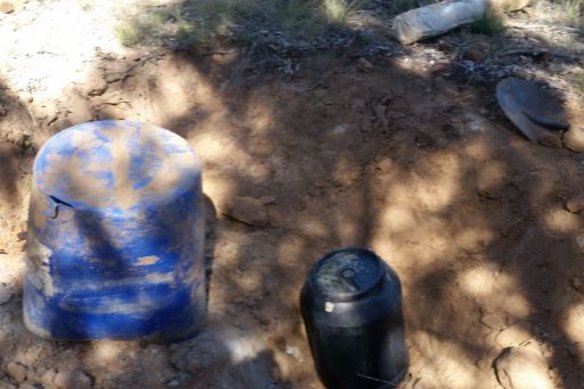 Police allegedly found the weapons buried in barrels on the property.