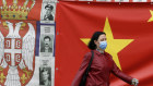 A woman walks by a Chinese flag in Belgrade, Serbia. Chinese envoys have set off diplomatic firestorms with a combative defence whenever their country is accused of not acting quickly enough to stem the spread of the coronavirus pandemic. 