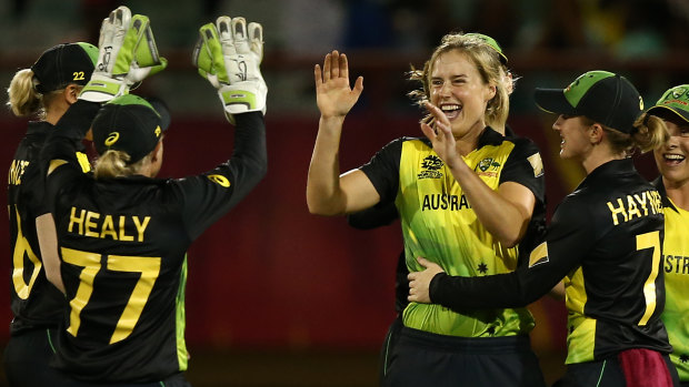 Ellyse Perry and teammates celebrate the wicket of New Zealand's Sophie Devine.