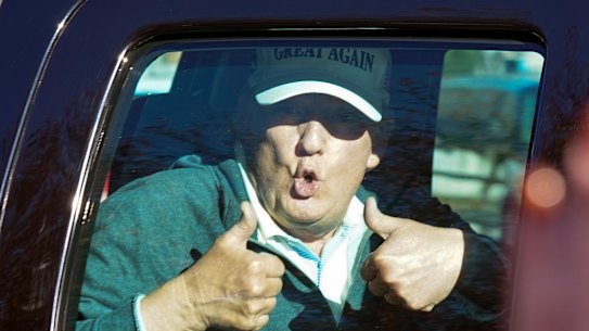 President Donald Trump gives two thumbs up to supporters outside his golf club after losing the presidential election.