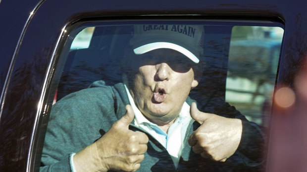 President Donald Trump gives two thumbs up to supporters outside his golf club after losing the presidential election.