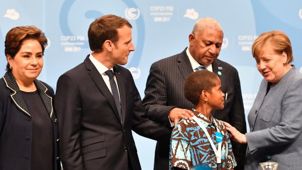 German Chancellor Angela Merkel, right, speaks with a Fijian child at climate talks in Germany in 2017.