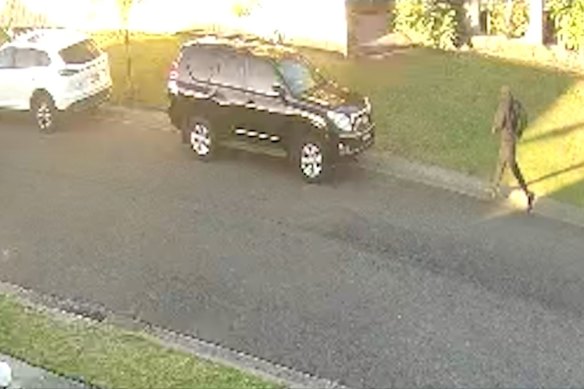 An unknown man running to a black Toyota Prado that police believe could be linked to the shooting of Marvin Oraiha. 