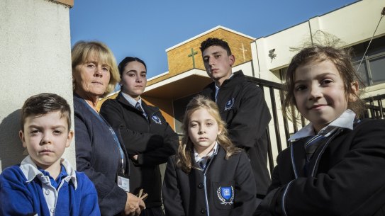 Alphington Grammar School principal Dr Vivianne Nikou stands with students Miles, Isabella, Zoe, Ethan and Nikoletta at the school gates.