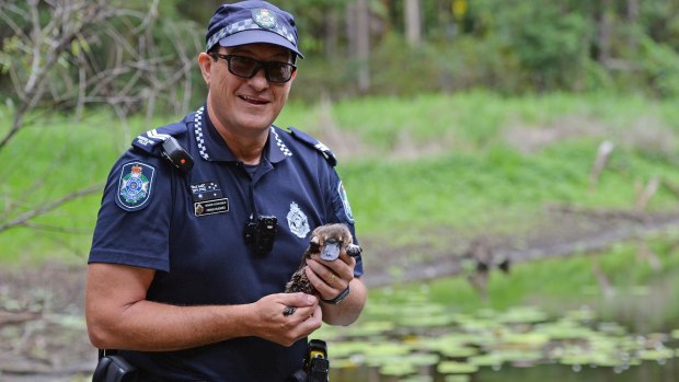 Queensland police Senior Constable Craig Hughes with Connie the platypus. 
