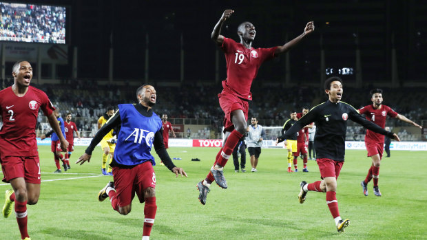 Jubilation: Qatar's players celebrate the stunning free kick that put them into the last four of the Asian Cup.