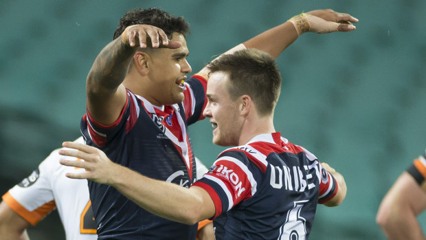 Latrell Mitchell celebrates with Luke Keary after scoring a try against the Tigers on Saturday. 