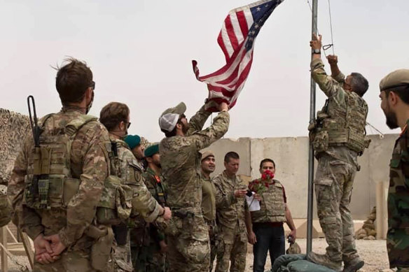 The US flag is lowered as American and Afghan soldiers attend a handover ceremony at Camp Anthonic in Helmand province.