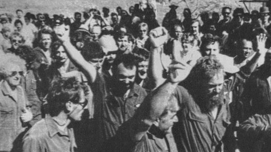 Robe River unionists, the first to return to work after a long-running dispute, greet each other with clenched fists in Pilbara, Western Australia. 03 September 1986. 