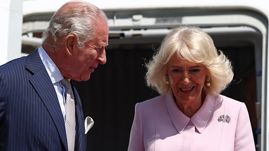 Rainha Camilla usando a Union Jack e o broche de estrelas e listras com o rei Charles.