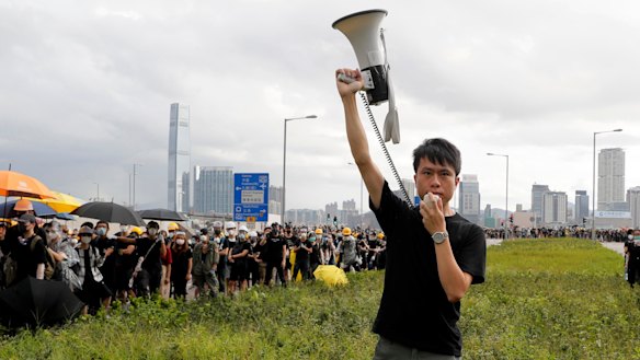 Pro-democracy lawmaker Roy Kwong speaks over a loud hailer to the police as he joins protesters in Hong Kong on July 1.