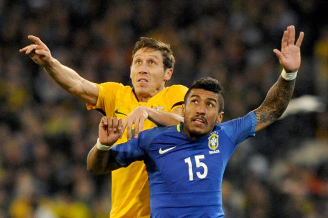 Case for the defence: Mark Milligan competes for the ball with Brazil's Jose Paulo. 