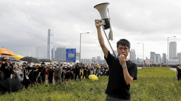 Pro-democracy lawmaker Roy Kwong speaks over a loud hailer to the police as he joins protesters in Hong Kong on July 1.