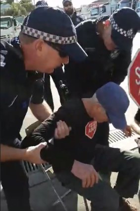 A protester being arrested outside concrete contractor Meales at Windsor.