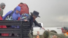 In this image from video provided by Rebecca Barger, festival goers are helped off a truck at the Burning Man festival site. 
