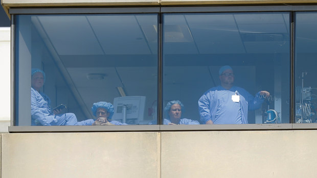 Medical personnel watch a protest against the arrival of President Donald Trump outside their hospital in Dayton.