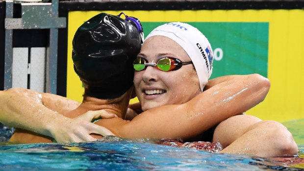 Emma McKeon hugs second place Cate Campbell in the 100m freestyle.