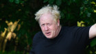 Boris Johnson waves to media on his morning run in Brightwell-cum-Sotwell in England.