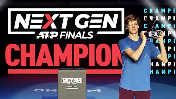 Jannik Sinner of Italy celebrates with the winner's trophy after defeating Alex de Minaur in the Next Gen ATP final.