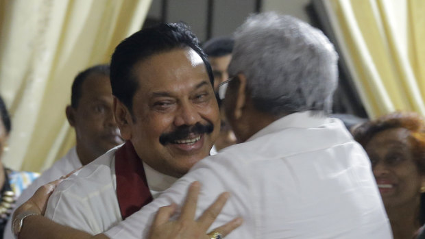 Newly appointed Sri Lankan Prime Minister Mahinda Rajapaksa, left, embraces his brother, former defence secretary Gotabhaya Rajapaksa, at a Buddhist temple in Colombo.