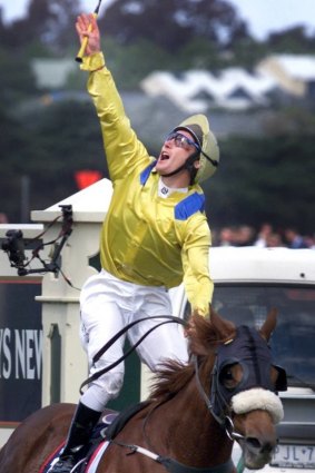Damien Oliver salutes his late brother after winning the 2002 Melbourne Cup. 