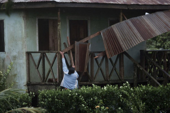 A woman works to recover a roof part damaged by hurricane Eta in Wawa, Nicaragua.