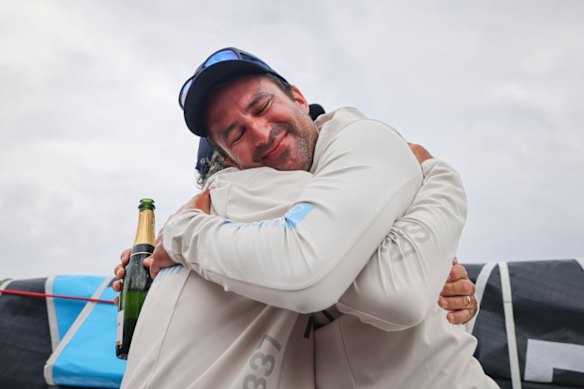 Yann Rigal and Michael Quintin, of BNC - my::NET / LEON, embrace after arriving at Constitution Dock, Hobart on Tuesday.
