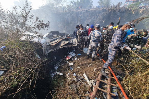 Rescue teams working at the wreckage of a Yeti Airlines ATR72 aircraft after it crashed in Pokhara, Nepal.