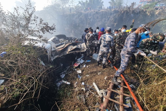 救援队在雪人航空公司 ATR72 飞机在尼泊尔博卡拉坠毁后的残骸上工作。