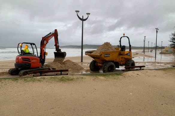 Sand is washed over Marine Parade in Maroubra on Tuesday after heavy rain and damaging surf.