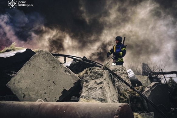 Rescue workers clear the rubble of a building destroyed by a Russian strike in Brovary, outside Kyiv, Ukraine, on Wednesday.