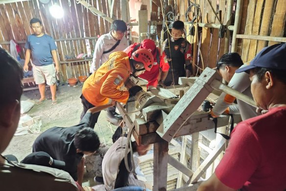 Search and rescue personnel peer into a mine shaft in Indonesia’s Central Java province, where eight workers have been trapped.