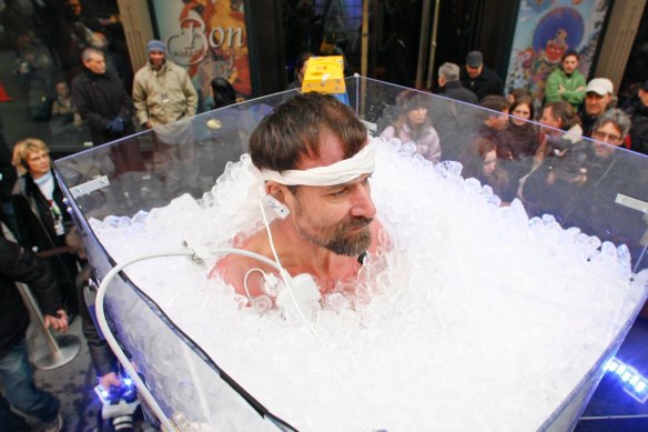 Wim Hof stands upright in a tub of ice during one of his record attempts.