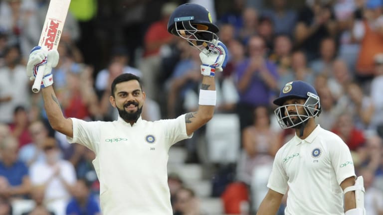 Well supported: Virat Kohli celebrates after scoring a century alongside teammate Ajinkya Rahane.