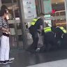Police officers apprehend a person at Northland after Sunday’s brawl.