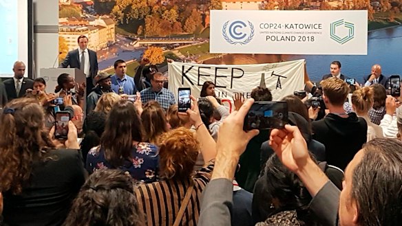 Protesters take over a stage to protest a pro-coal event at the COP24 climate talks in Katowice, Poland.